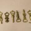 Brass bottle opener with figurines